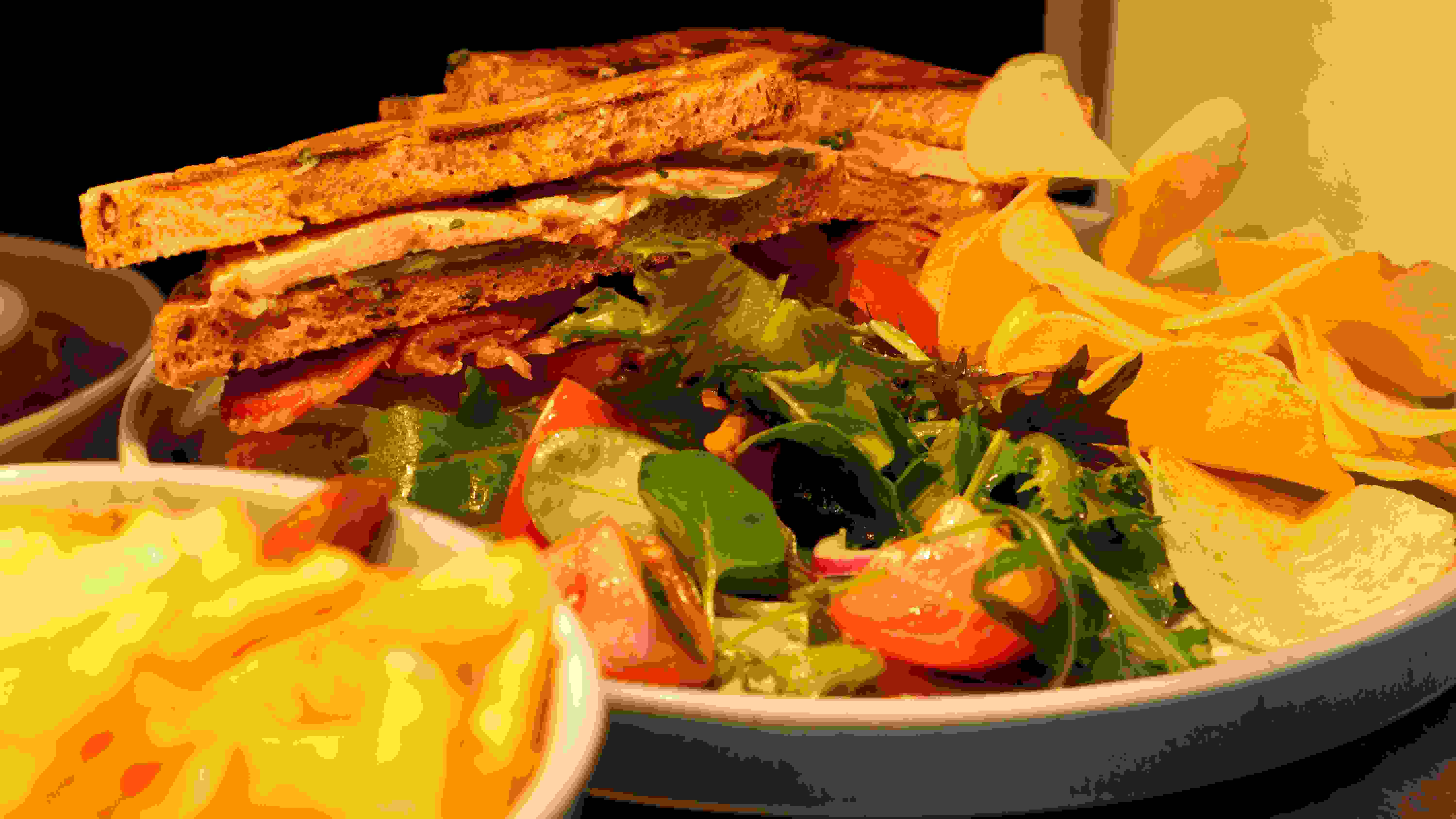 Toasted club sandwich with dressed salad and crisps
